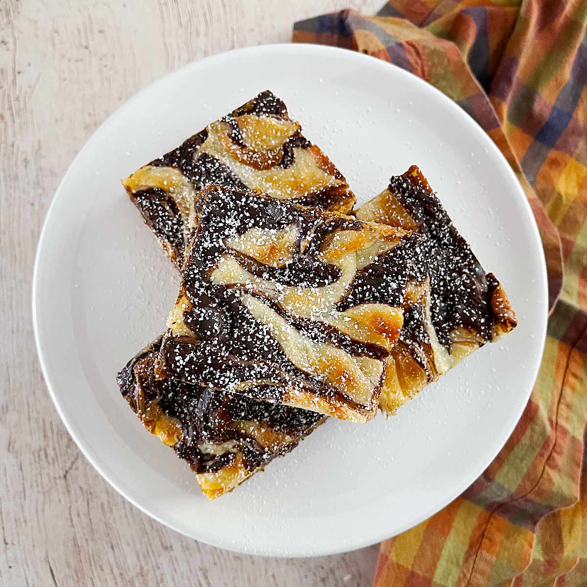 Plate with pumpkin bars with dusting of powdered sugar.