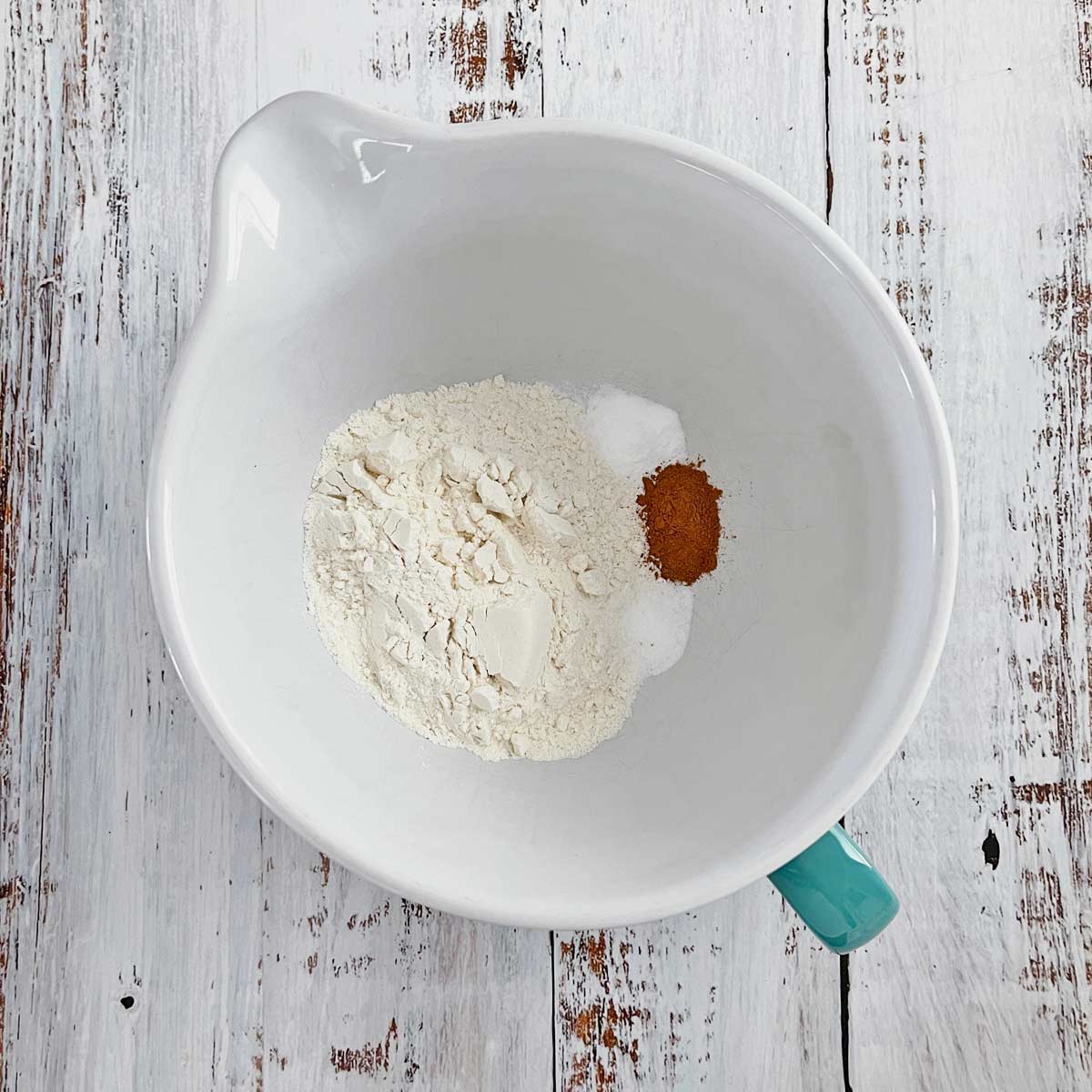 Mixing bowl with flour, salt, baking powder, and cinnamon.