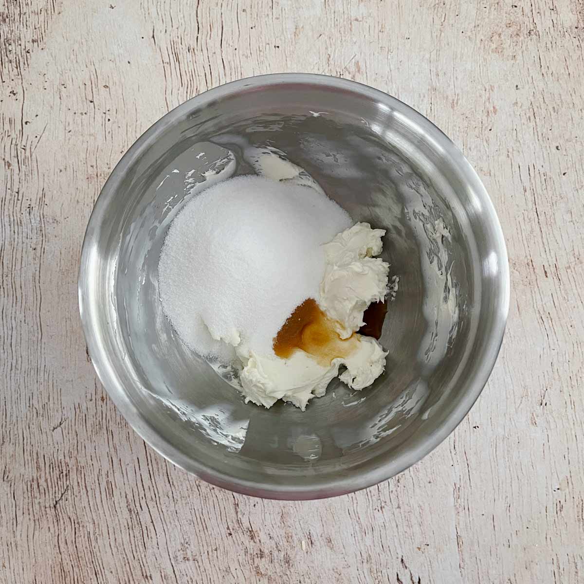 Mixing bowl with whipped cream cheese, sugar, and vanilla.