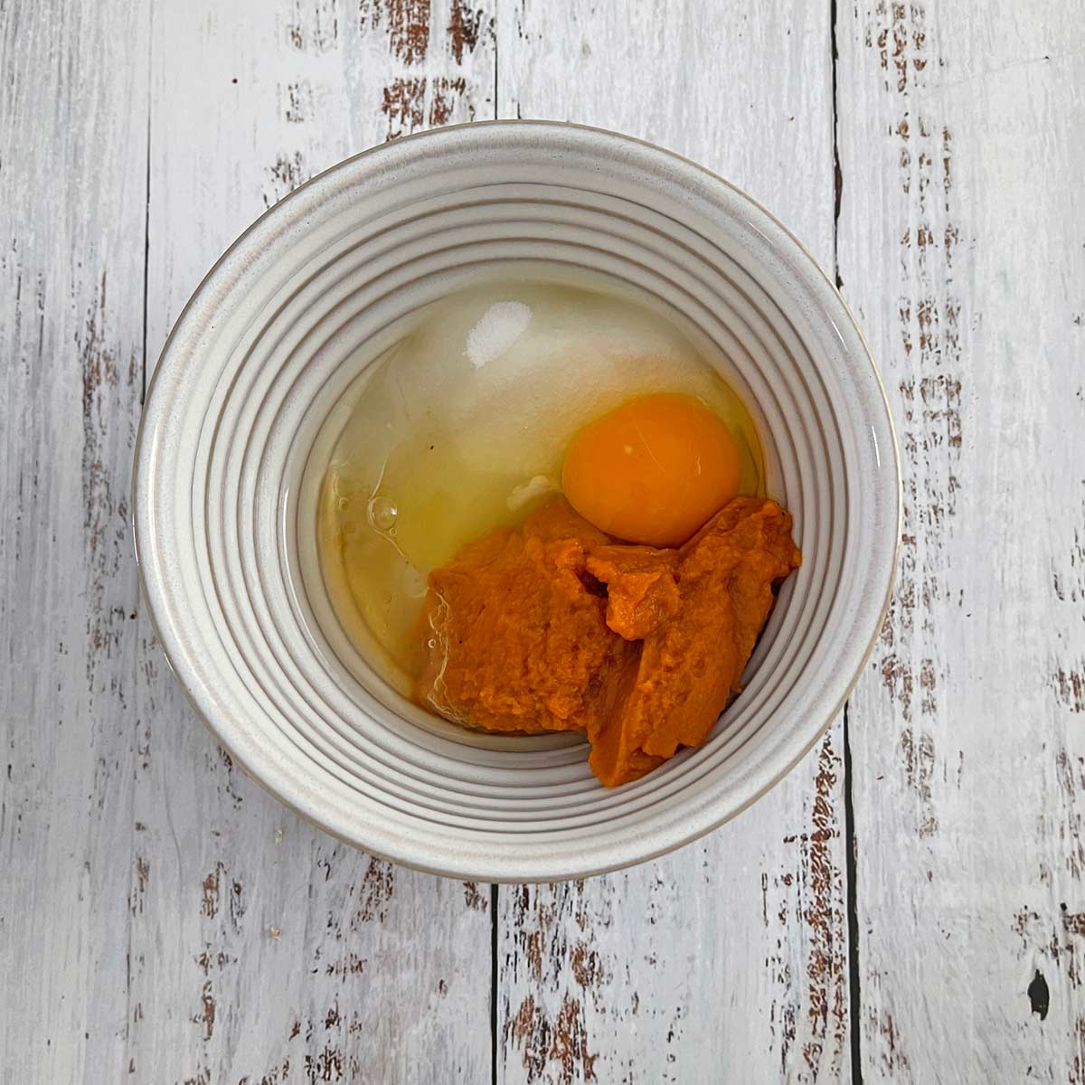 Medium bowl with pumpkin, sugar, oil, egg, and brandy.