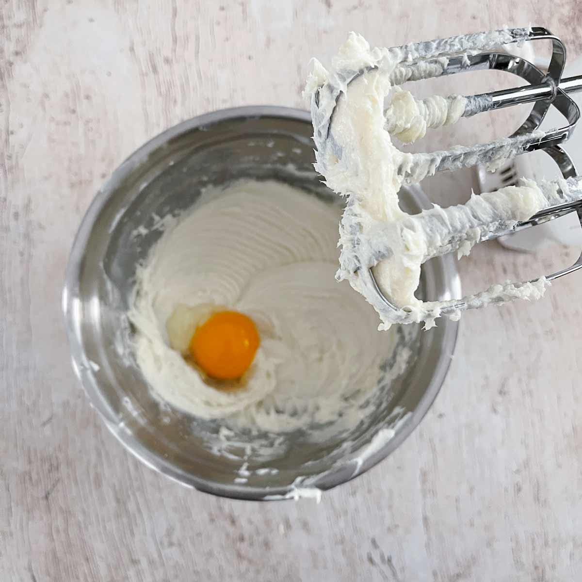 Bowl with the beaten cream cheese mixture with an egg added.