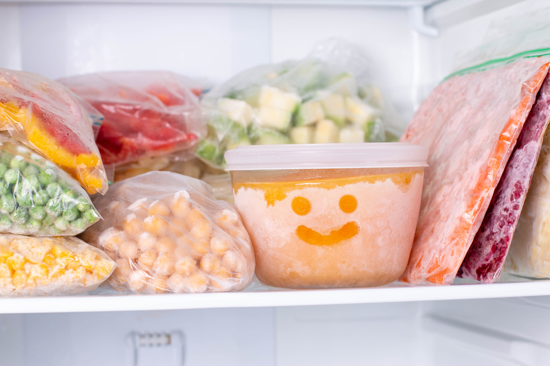 Frozen food with a smiley face in the frost on a plastic container.