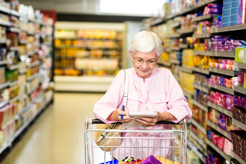 Elderly lady shopping with a shopping list.