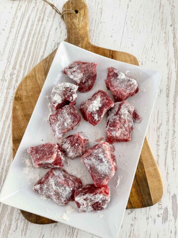 Beef chuck cubes covered in a light flour dusting.