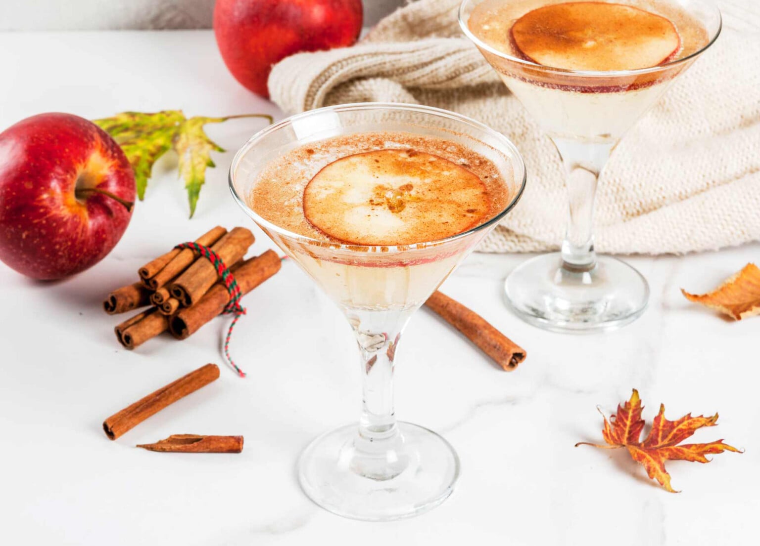 Two cocktail glasses with an apple cider margarita.