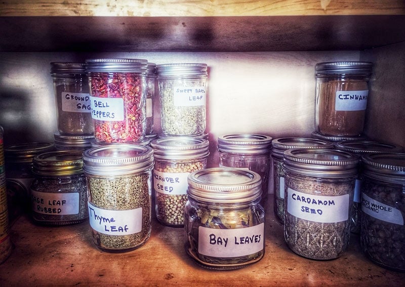 Labeled spice jars in cabinet.