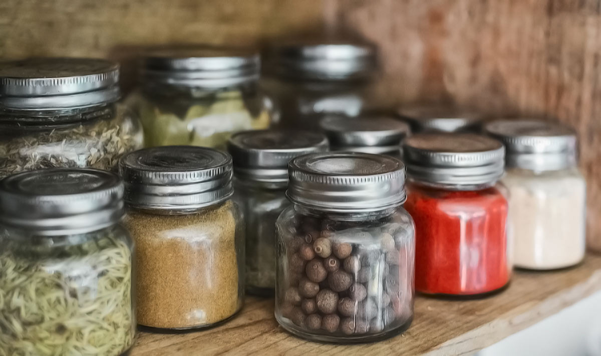 Jars of spices in cupboard.