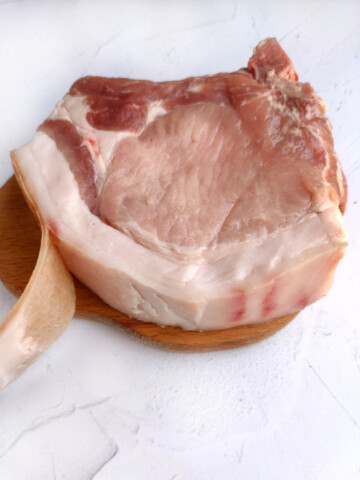 Thick pork chop with the skin being removed.