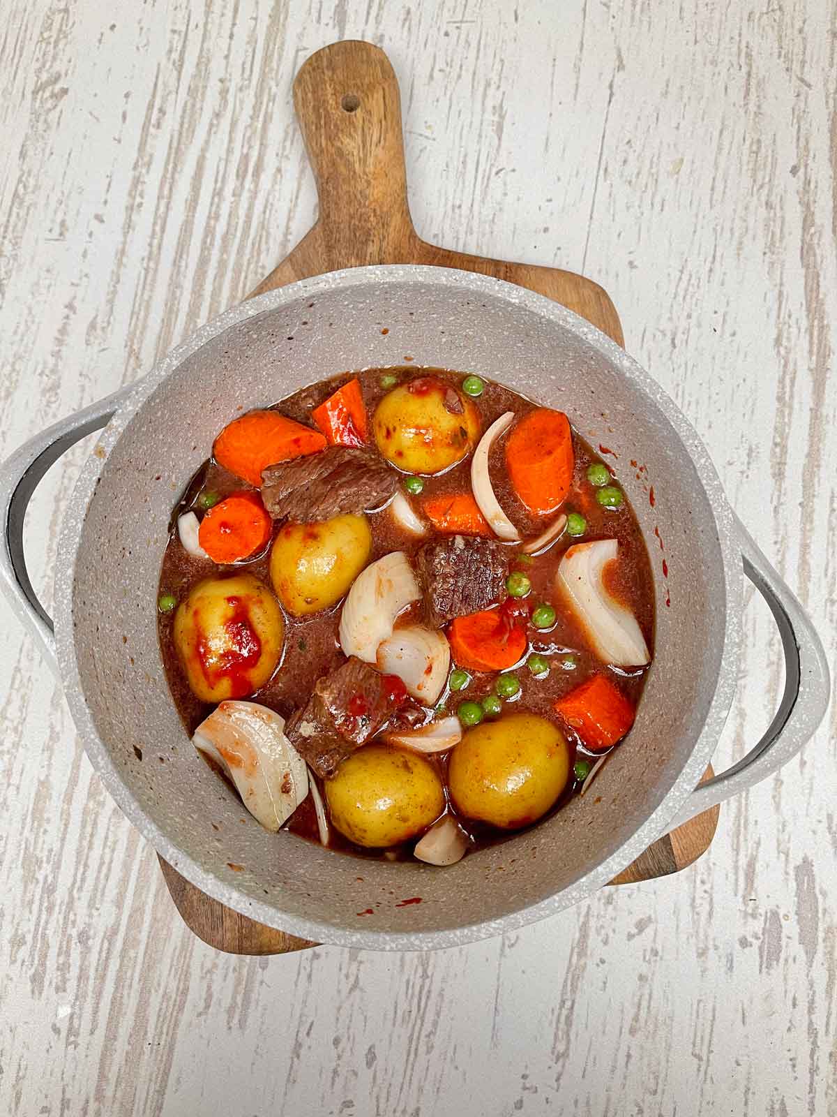 Stew and vegetables stirred together to finish cooking.