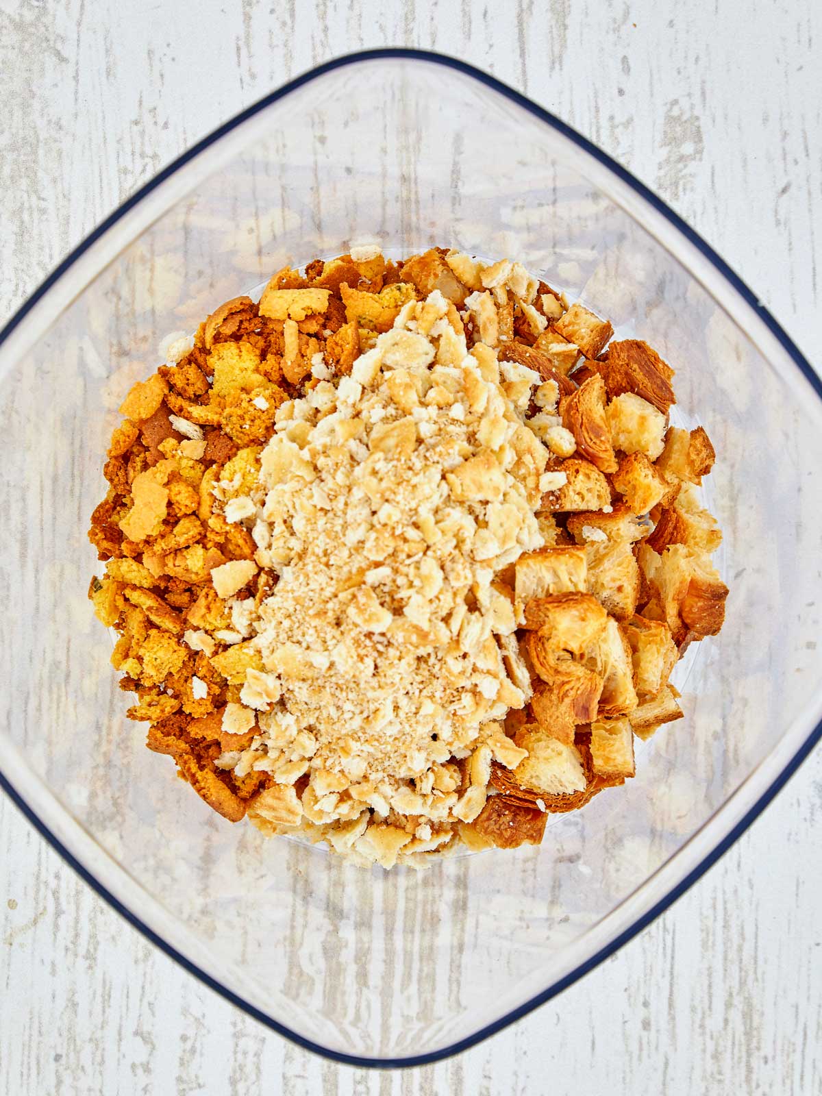 Stale cornbread, croissants, and crushed Ritz crackers in a lareg bowl.