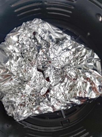 Tim foil pouch with pork chops inside.