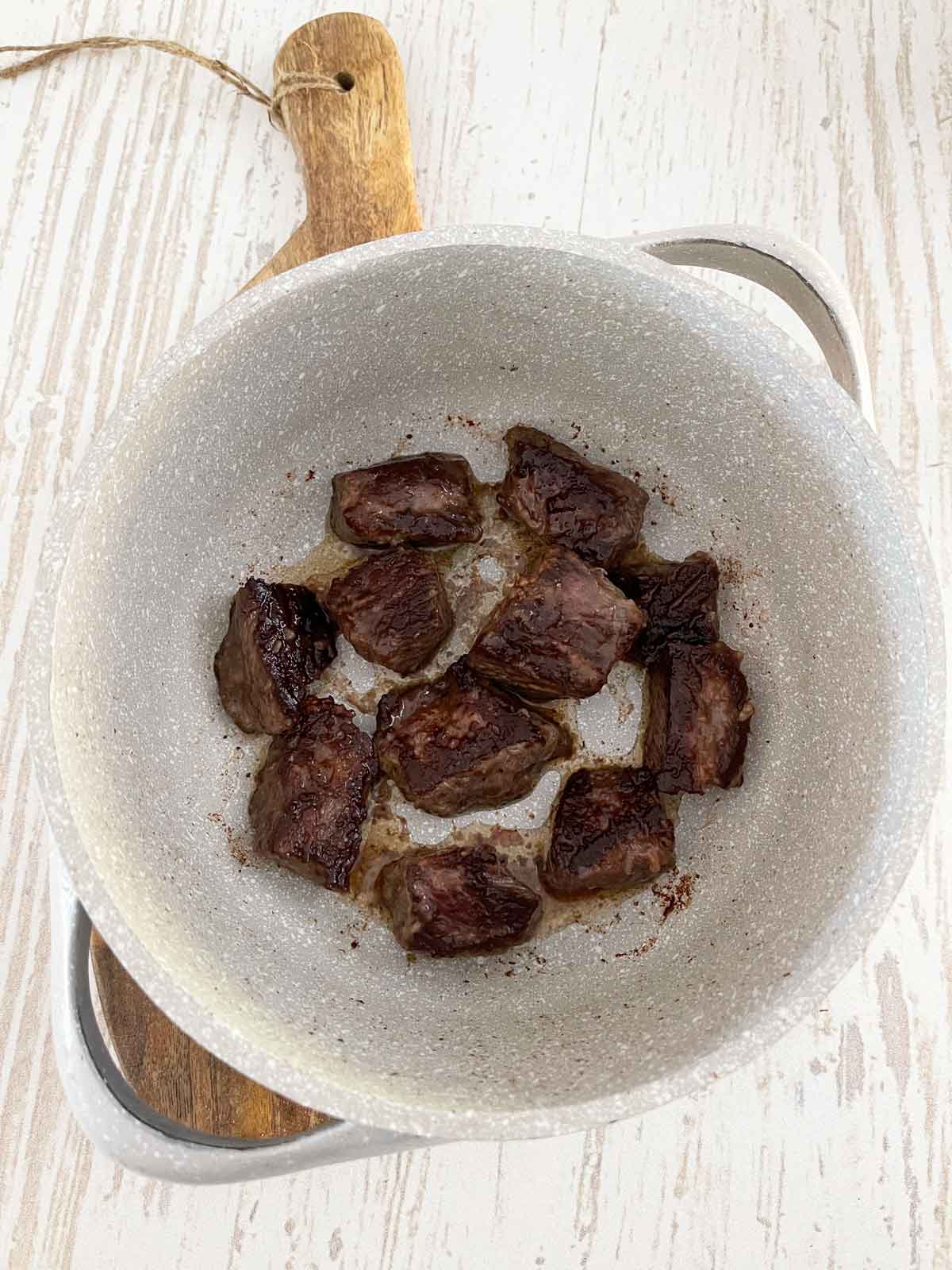 Chuck roast in a Dutch oven with browned edges.