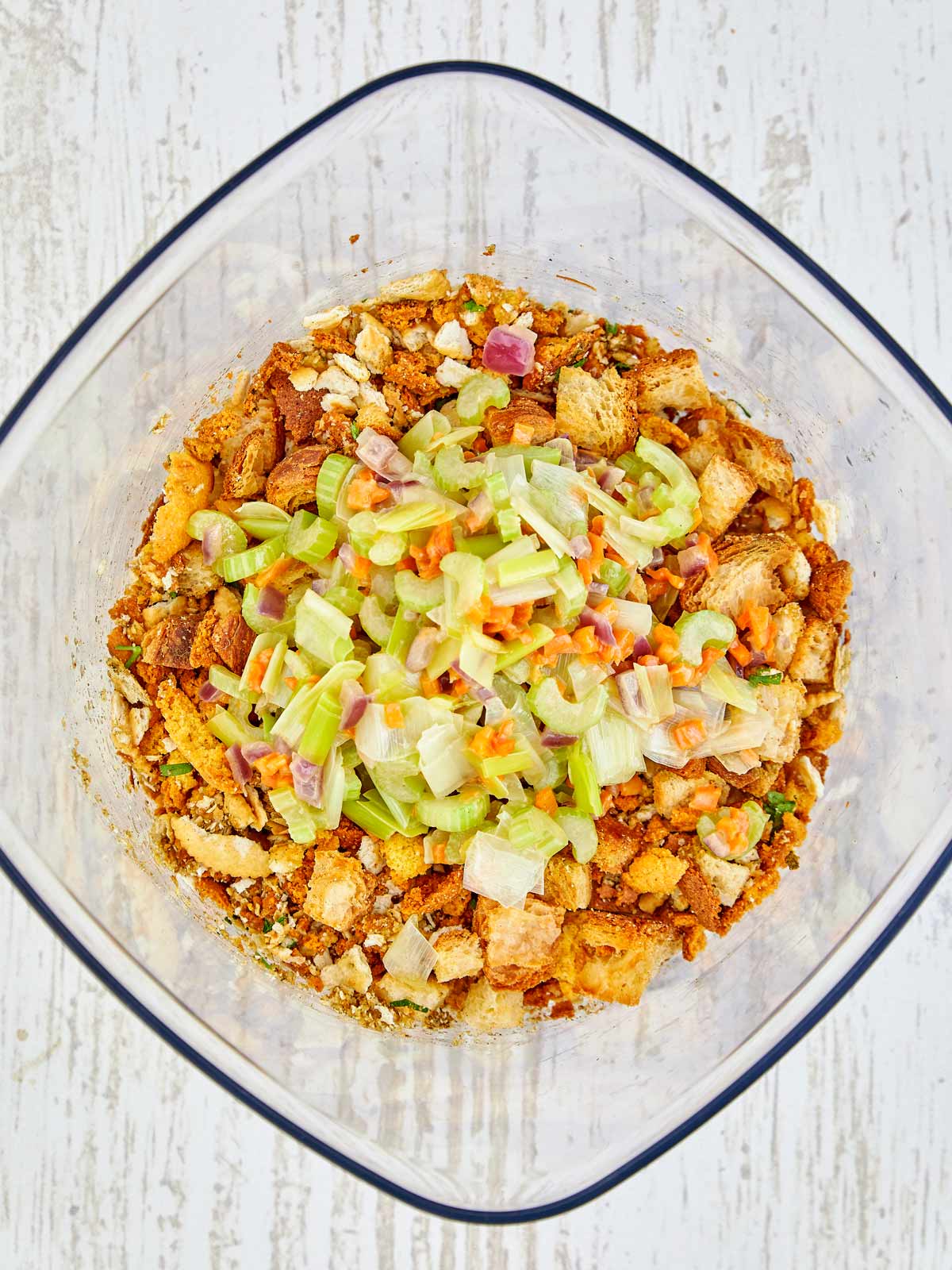 The cooked vegetables added to the large bowl with the bread.