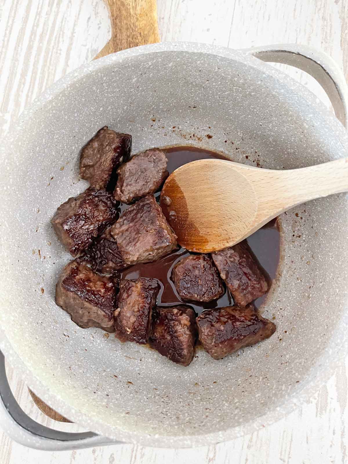 Dutch oven with red wine added to de-glaze the pan and scrape up the browned bits.