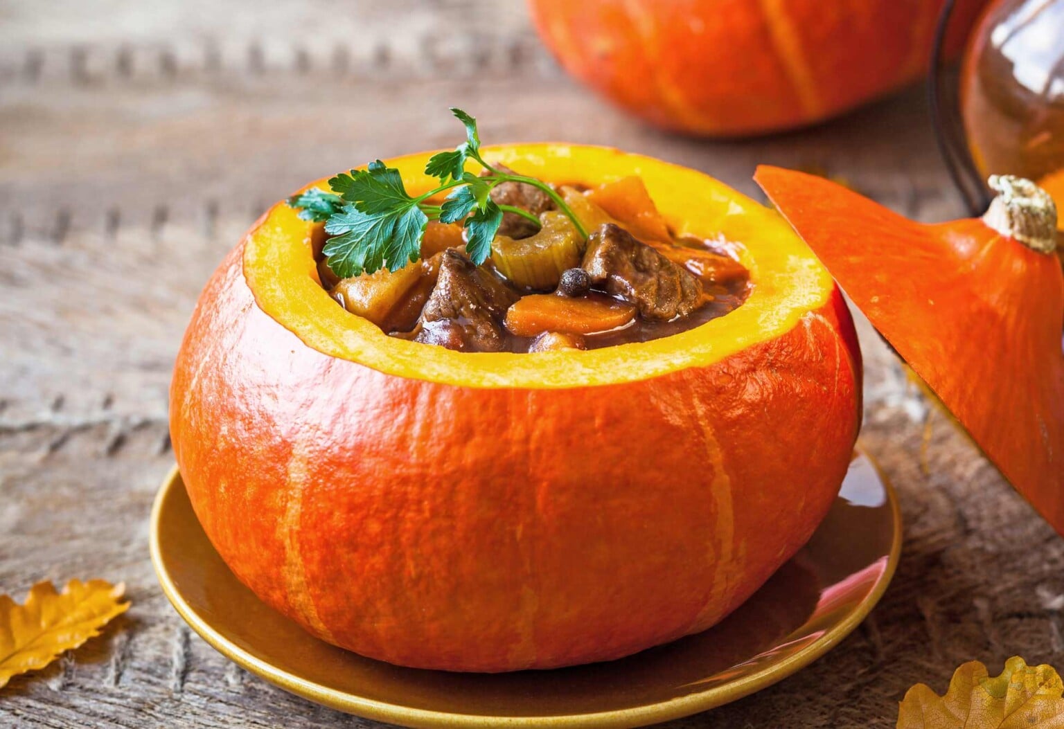 A beautiful orange pumpkin filled with beef stew.