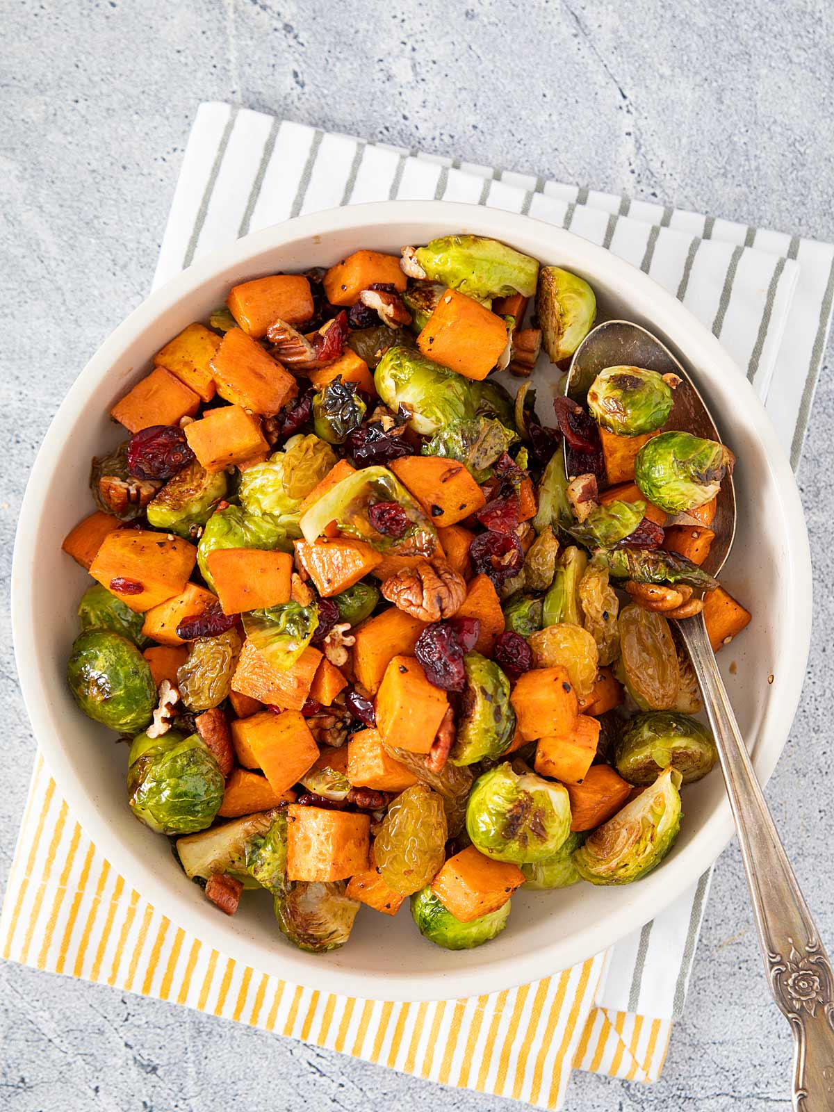 Bowl of Brussels Sprouts, Sweet potatoes, pecans, dried cranberries, and golden raisins.