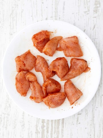 Raw chicken cubes with seasoning rubbed in.