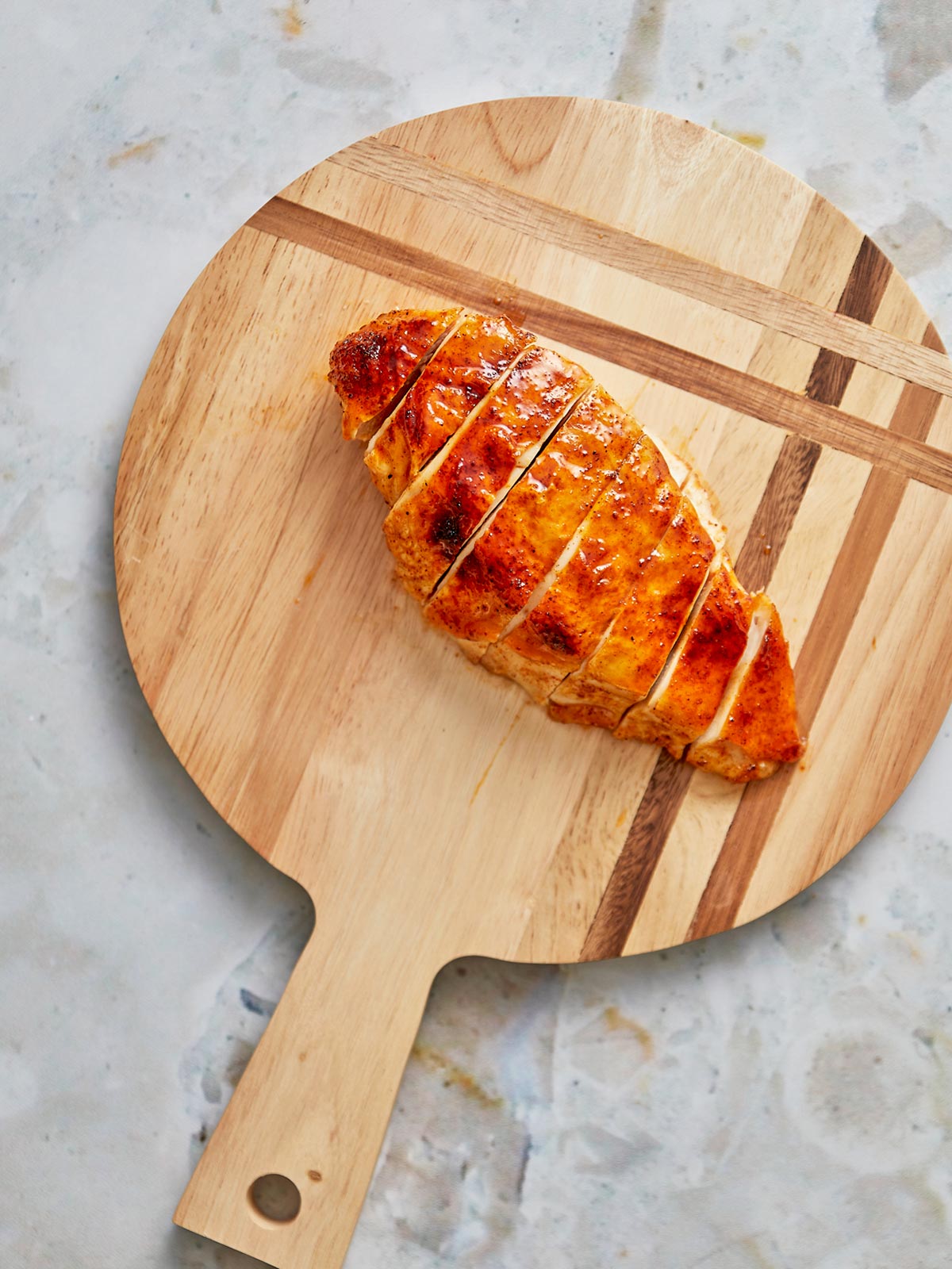 Sheet pan with cooked sliced chicken breast.