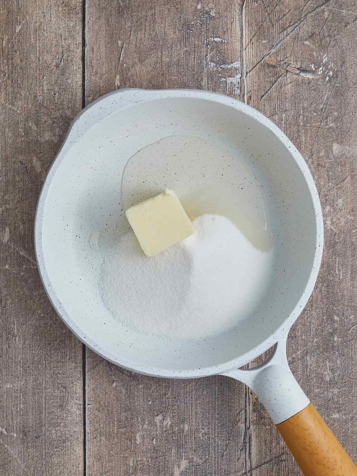 Saucepan with the glaze ingredients, sugar, wine, and butter in the bottom.