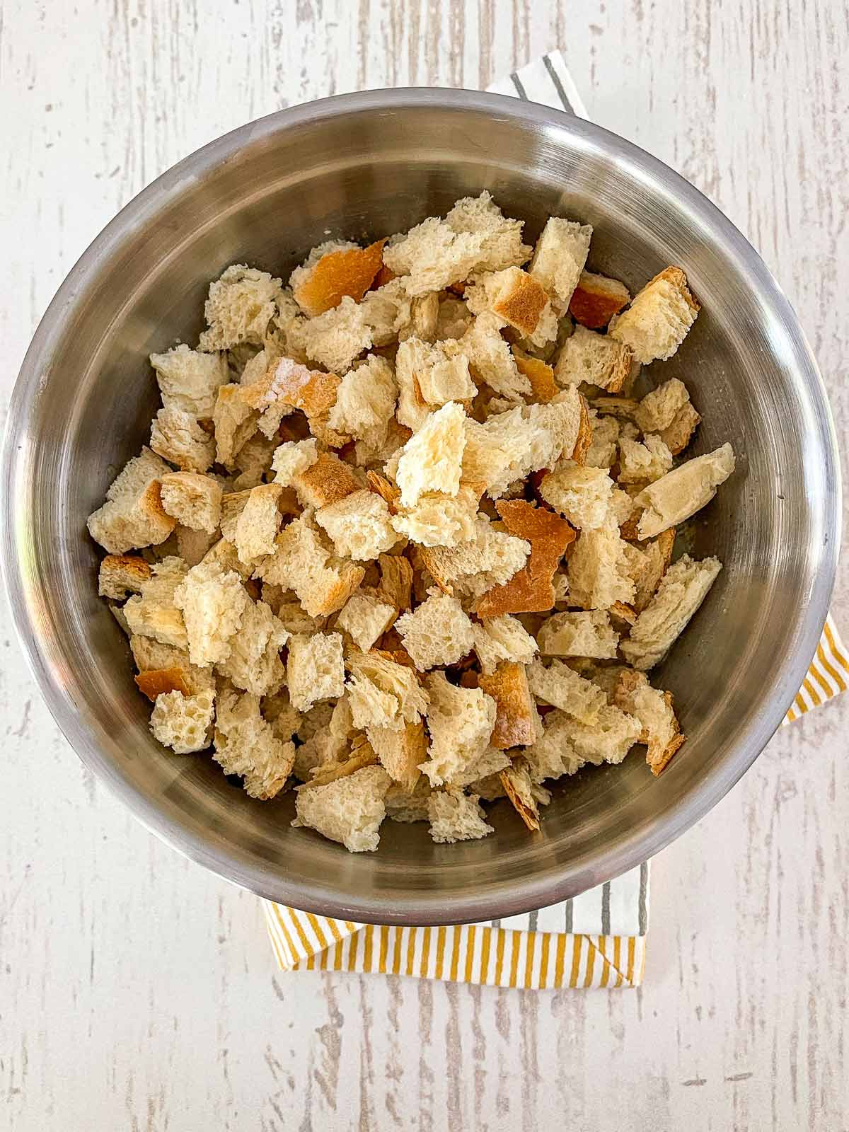 Adding the dry bread pieces to the bowl.