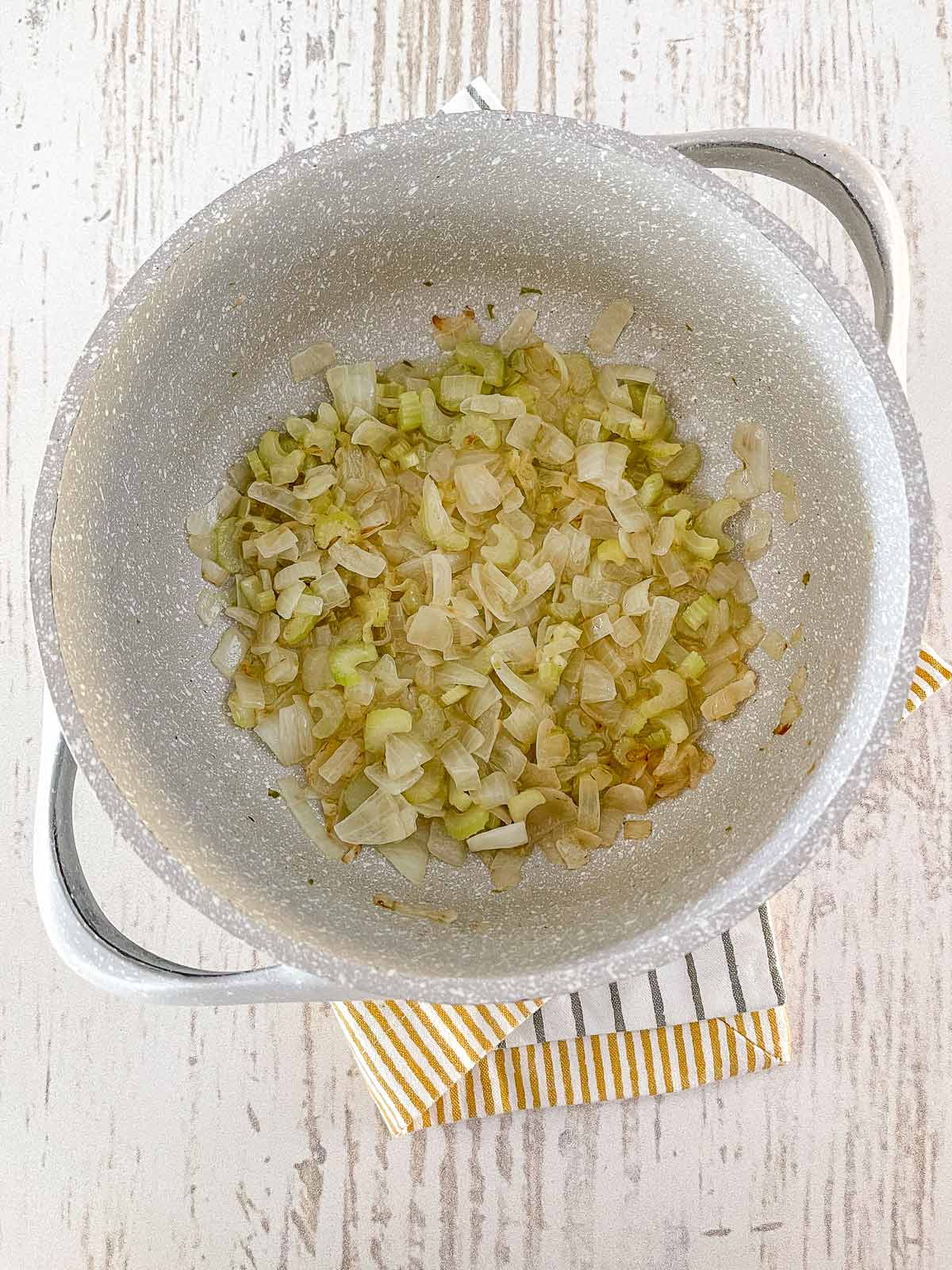 Pot with cooked onions and celery.