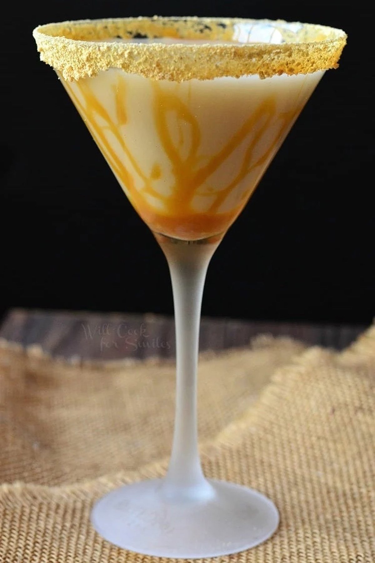 Caramel cake martini with caramel striped on inside of glass.