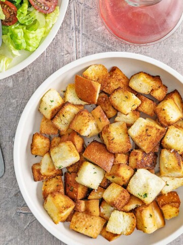 Air-fried crispy croutons, sitting beside a green salad and dressing.