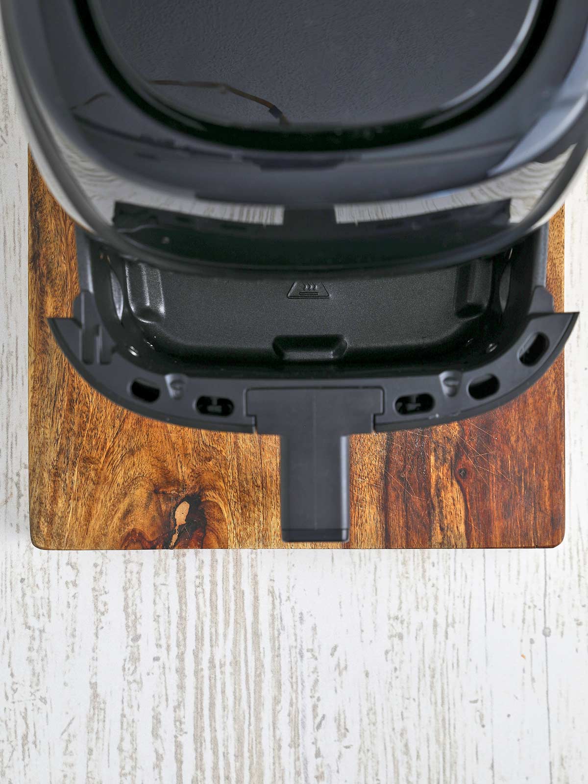Air fryer with empty basket partially out.