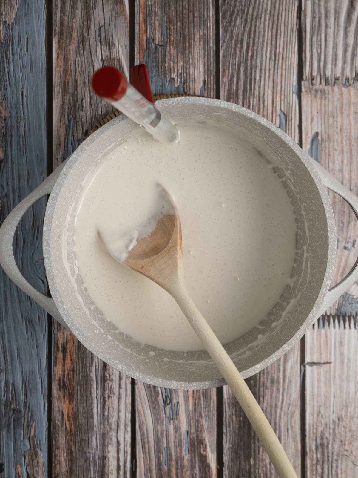 Pot with candy thermometer and cooking sugar mixture.