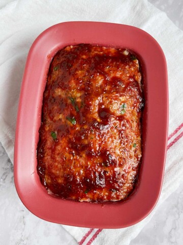 Uncooked meatloaf with glaze on top.