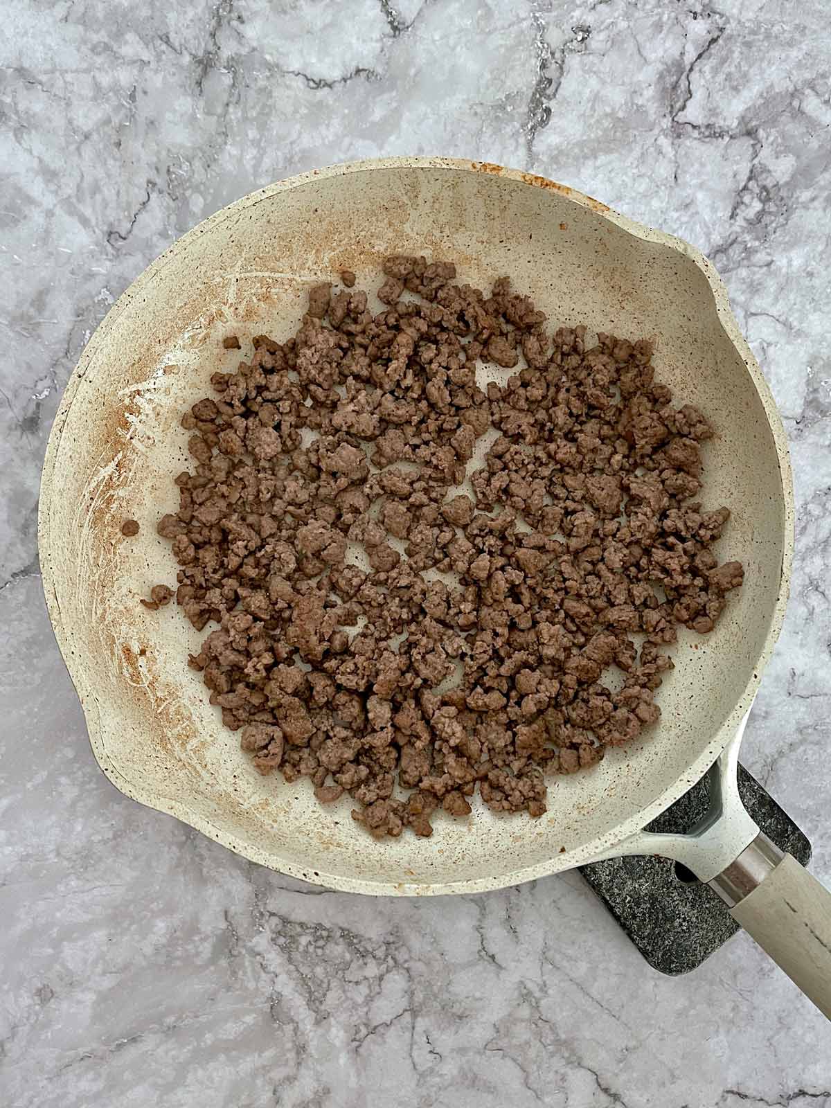 Ground beef browned in a skillet.