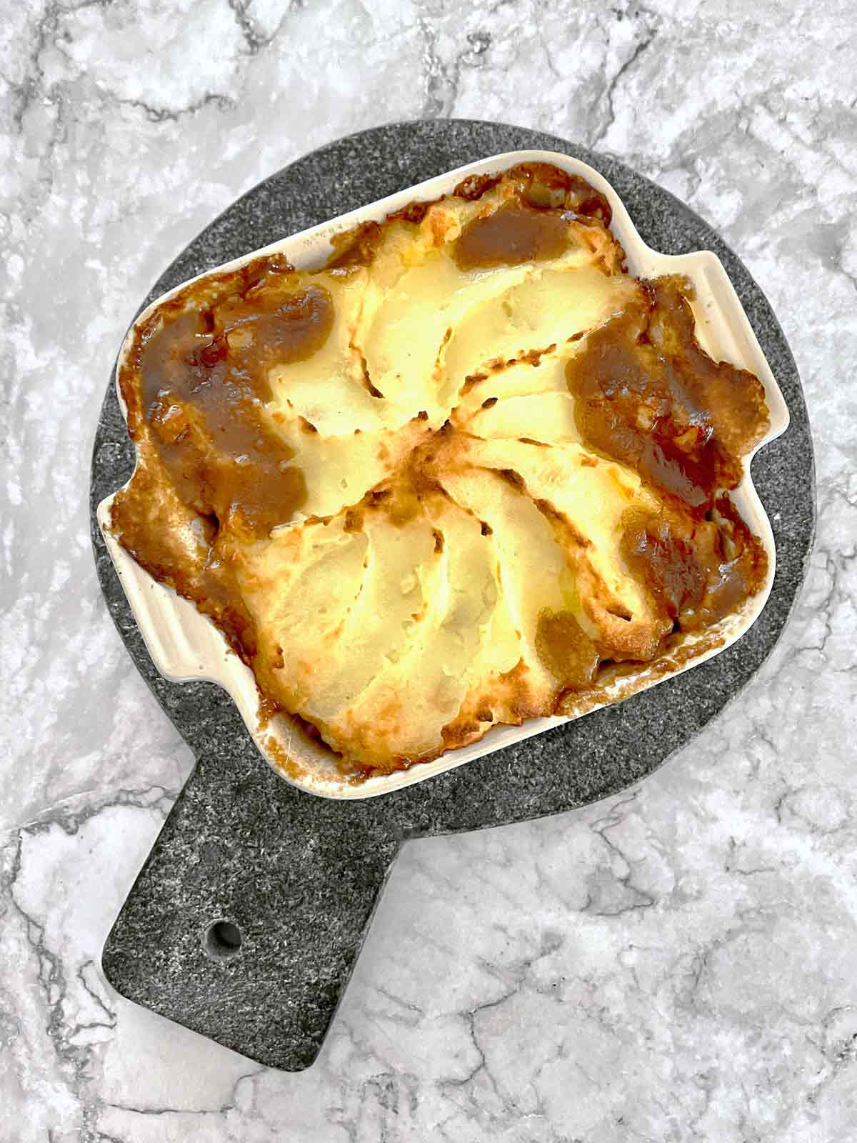 Fully baked she[herd's pie with bubbly gravy along edges.