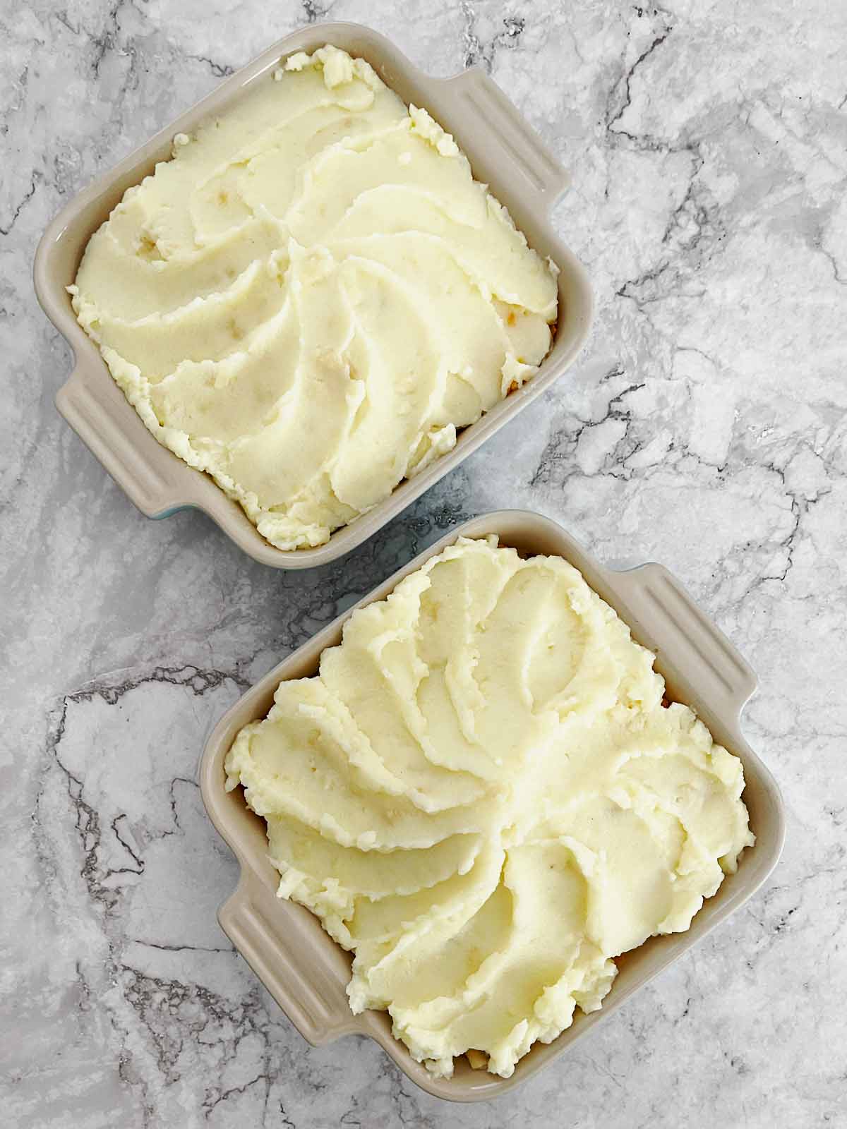 Baking sidhes with ashed potatoed placed over the top of the cheese.