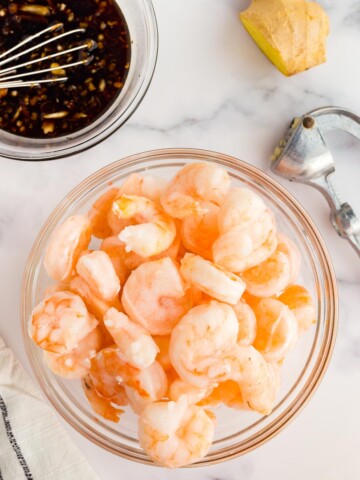 Bowl of frozen uncooked shrimp.