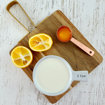 Lemons and heavy cream on a cutting board.