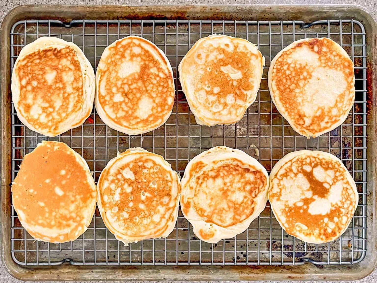 Pancakes on a sheet pan with a wire rack.