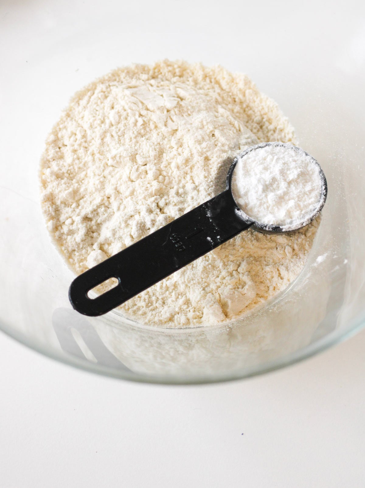 Bowl with flour in it and powered sugar being added.