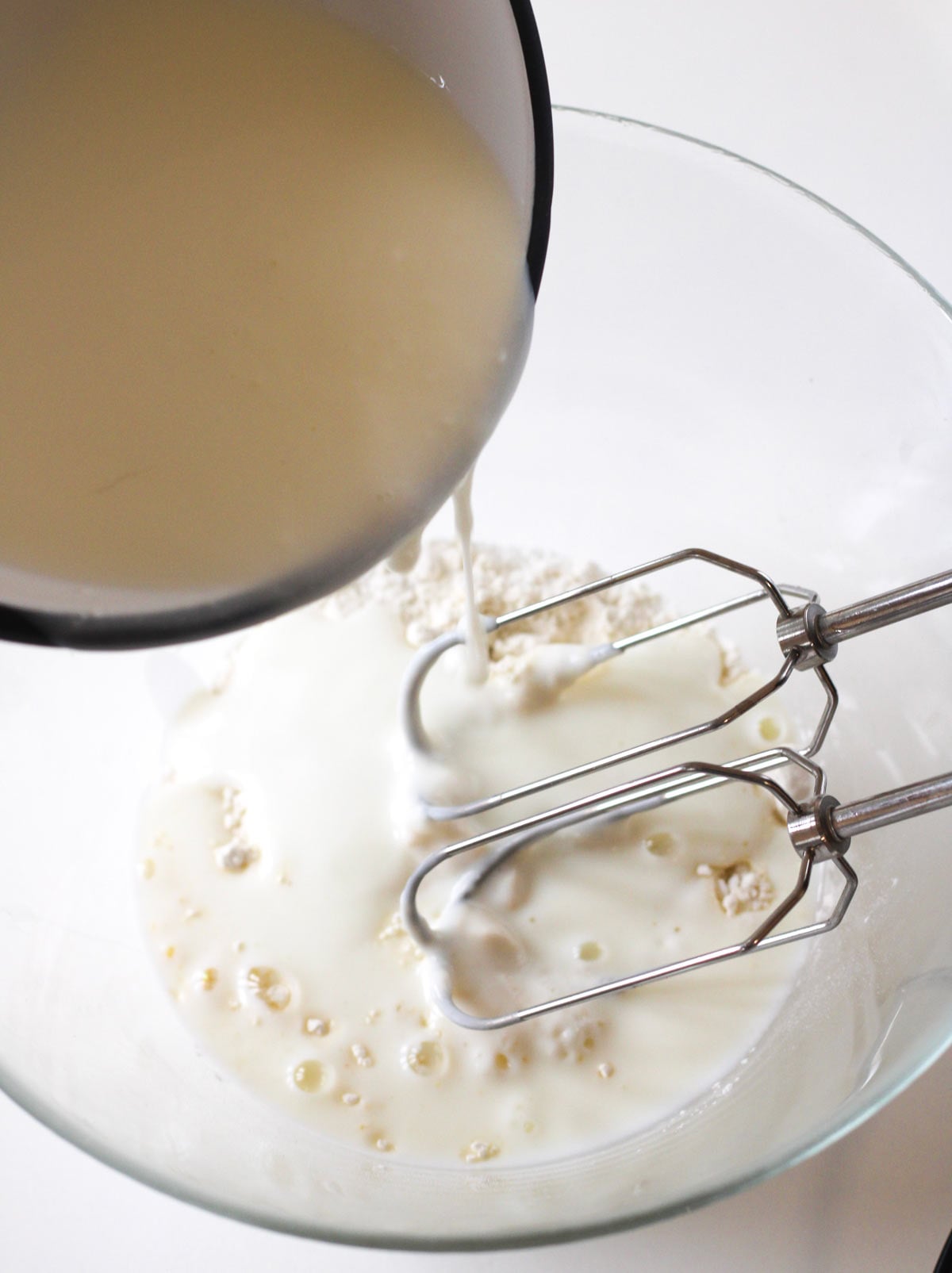 Buttermilk being poured into dry ingredients.