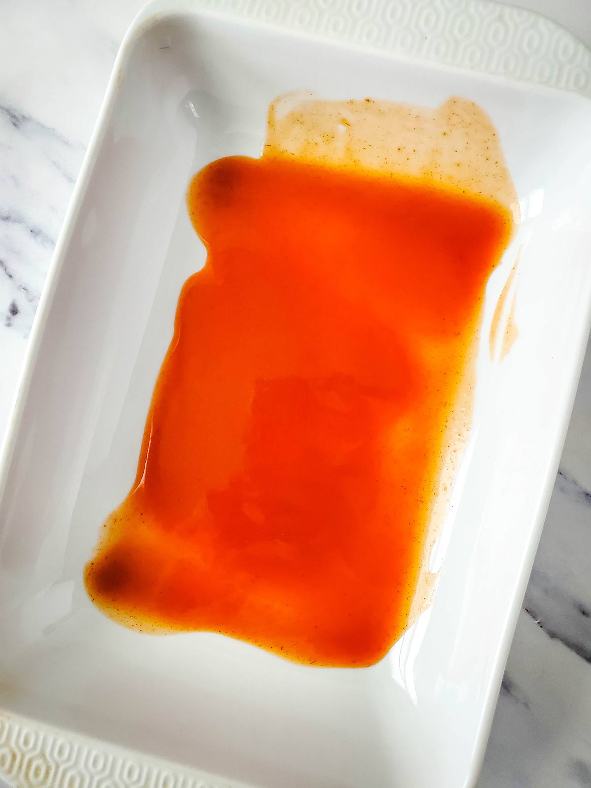 Enchilada sauce in bottom of casserole dish.