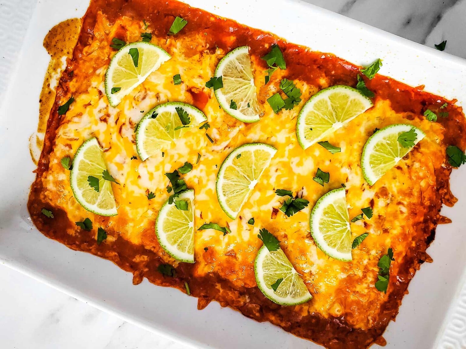 Golden brown, fully baked Taquito Casserole with lime cilantro garnish