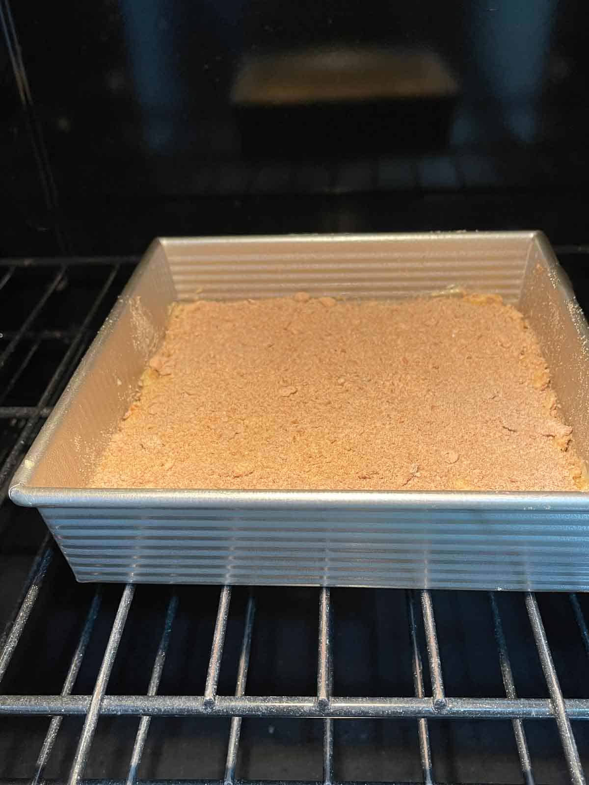 Cake pan being placed into hot oven to bake.