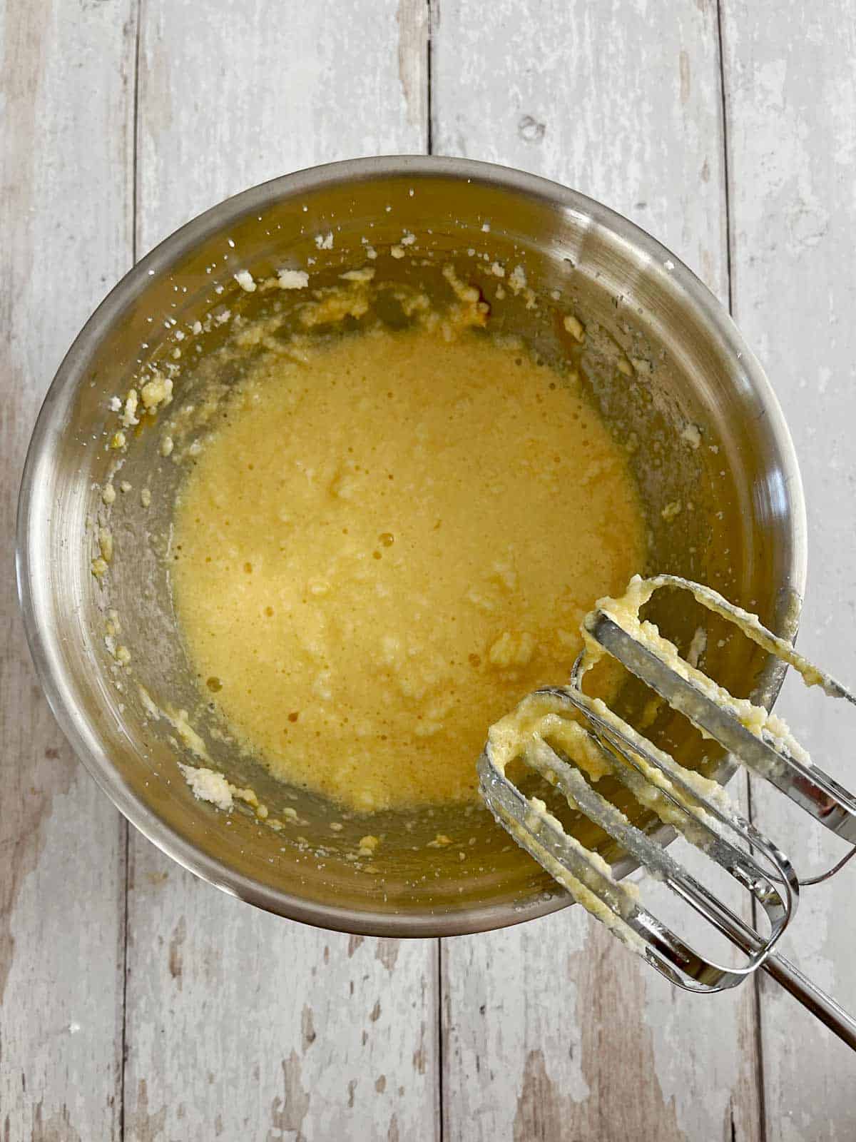 Eggs added to large bowl and mixed with handheld mixer.