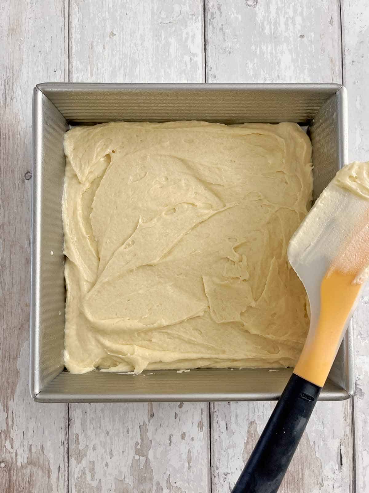 Half the batter spread out over the bottom of the cake pan.