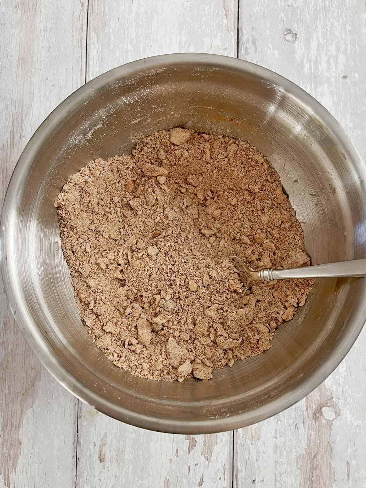Fork in bowl mixing the ingredients into the streusel topping.