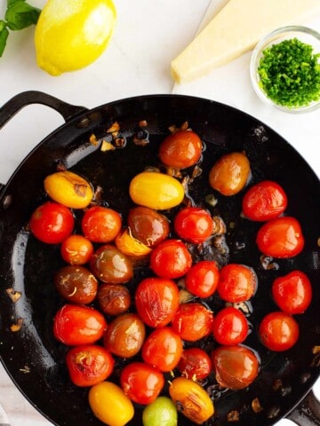 Skillet with cooked tomatoes and lemon zest.