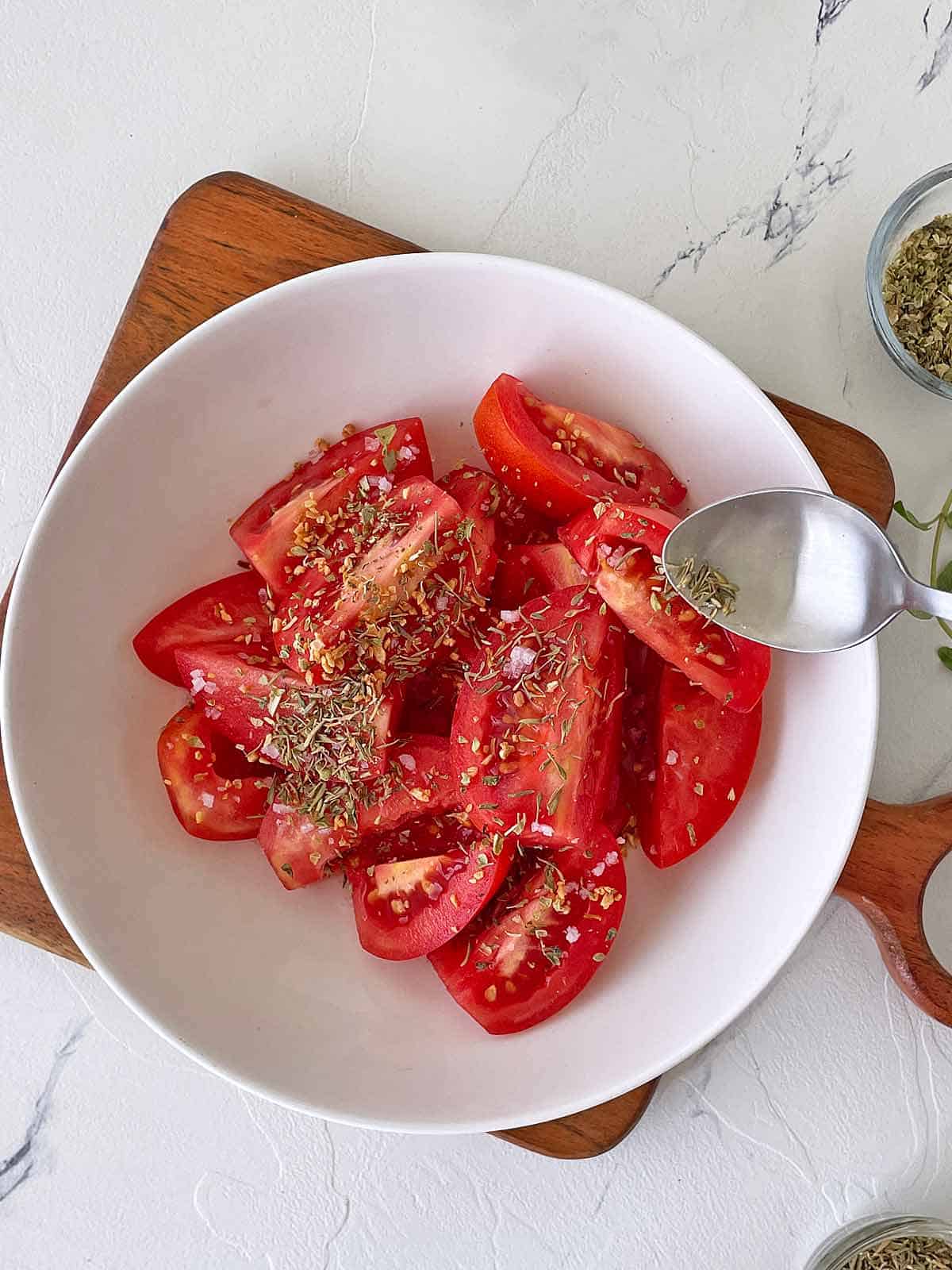 Bowl of tomatoes, cut and seasoned.