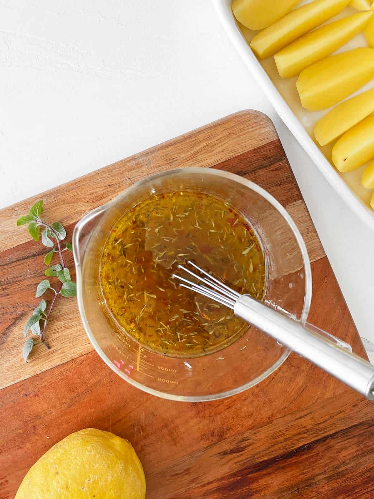 Liquid ingredients being whisked together in a large glass measuring cup.