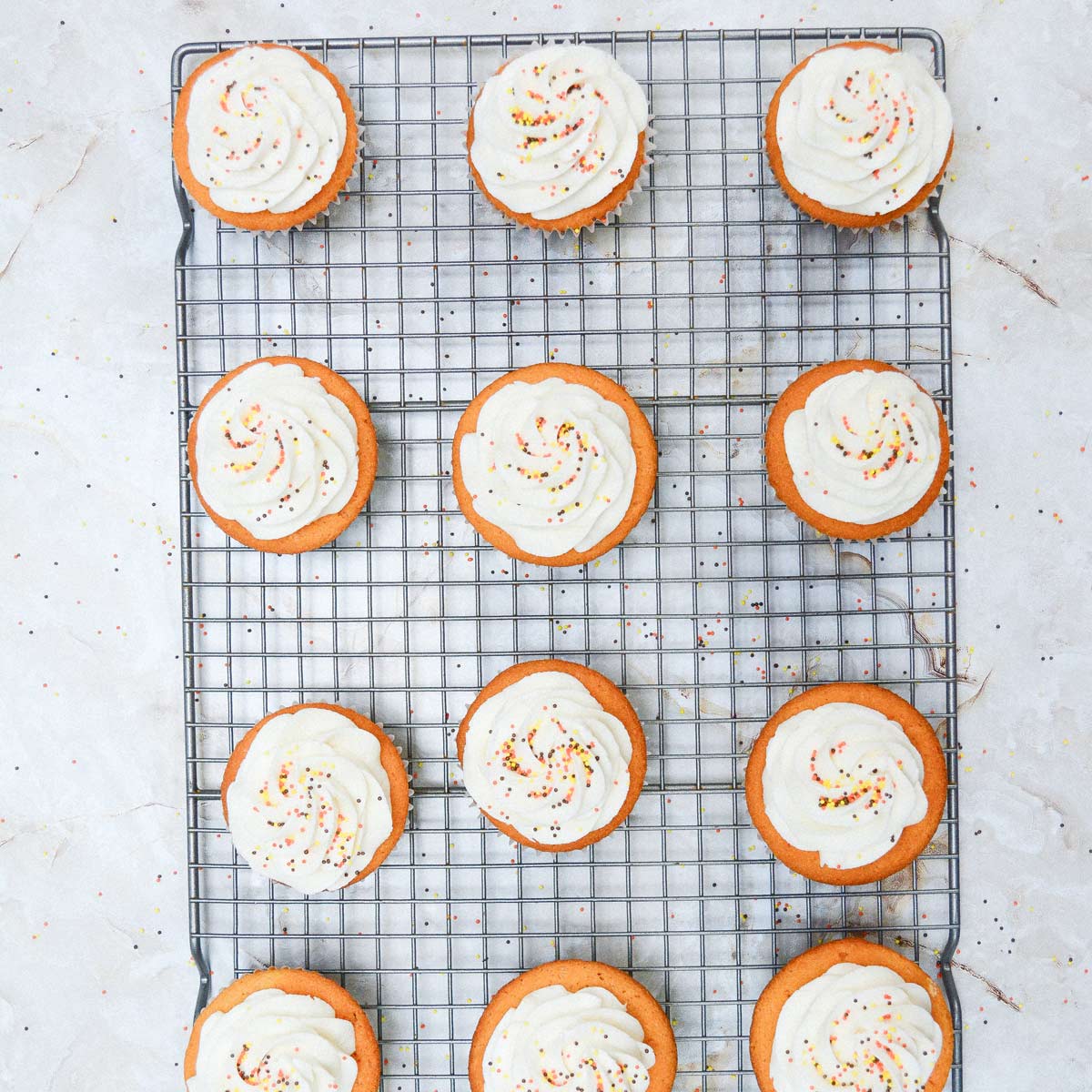 Frosted cupcakes with sprinkles on top.