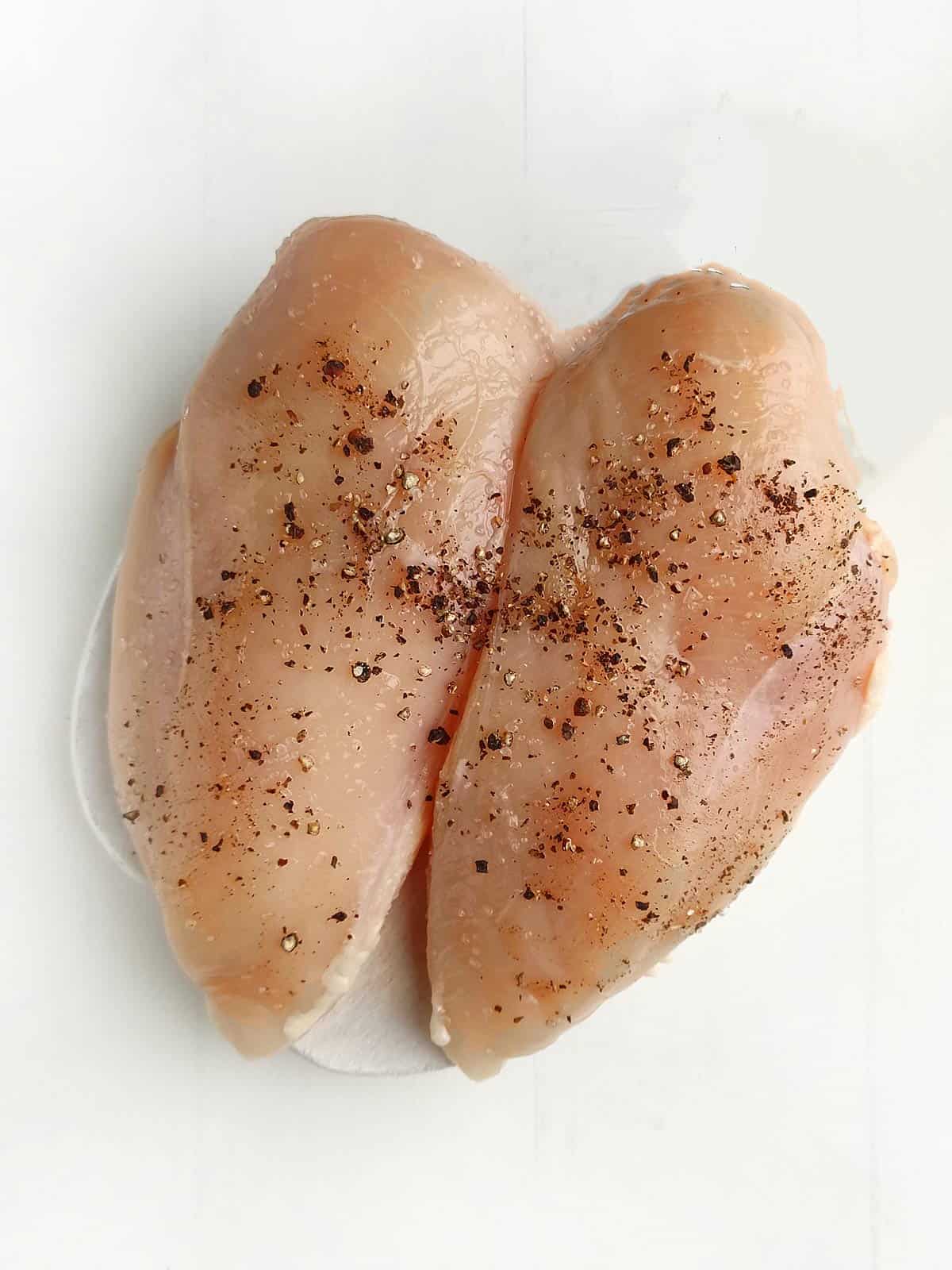 Chicken breast seasoned with salt, pepper, and spices.