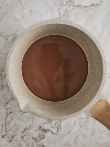 pot with milk and cocoa powder simmer together.
